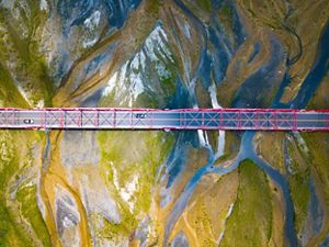 Aerial view looking straight down on a bridge that crosses a wide river.