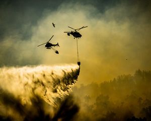 Helicopters prepare to drop water on a wildfire in Spain in 2023.