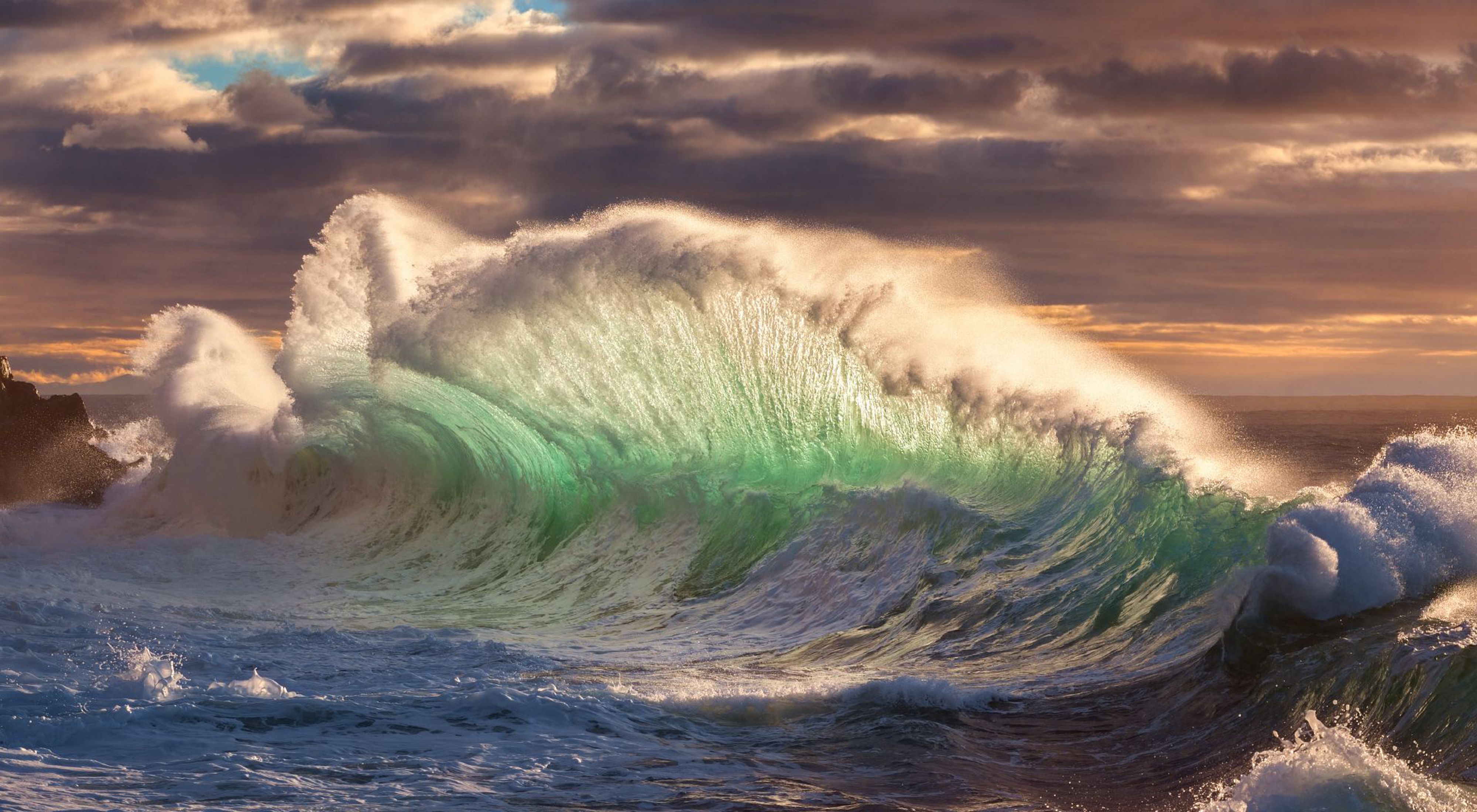 A wave breaks as the ocean swells towards the shore.