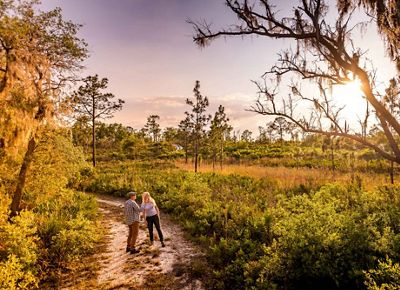 Two hikers explore the trails of Tiger Creek Preserve in Florida.