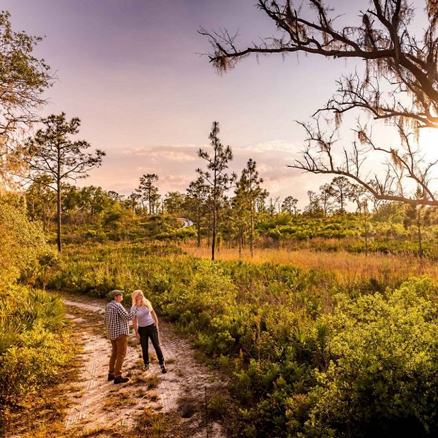 Two hikers explore the trails of Tiger Creek Preserve in Florida. 