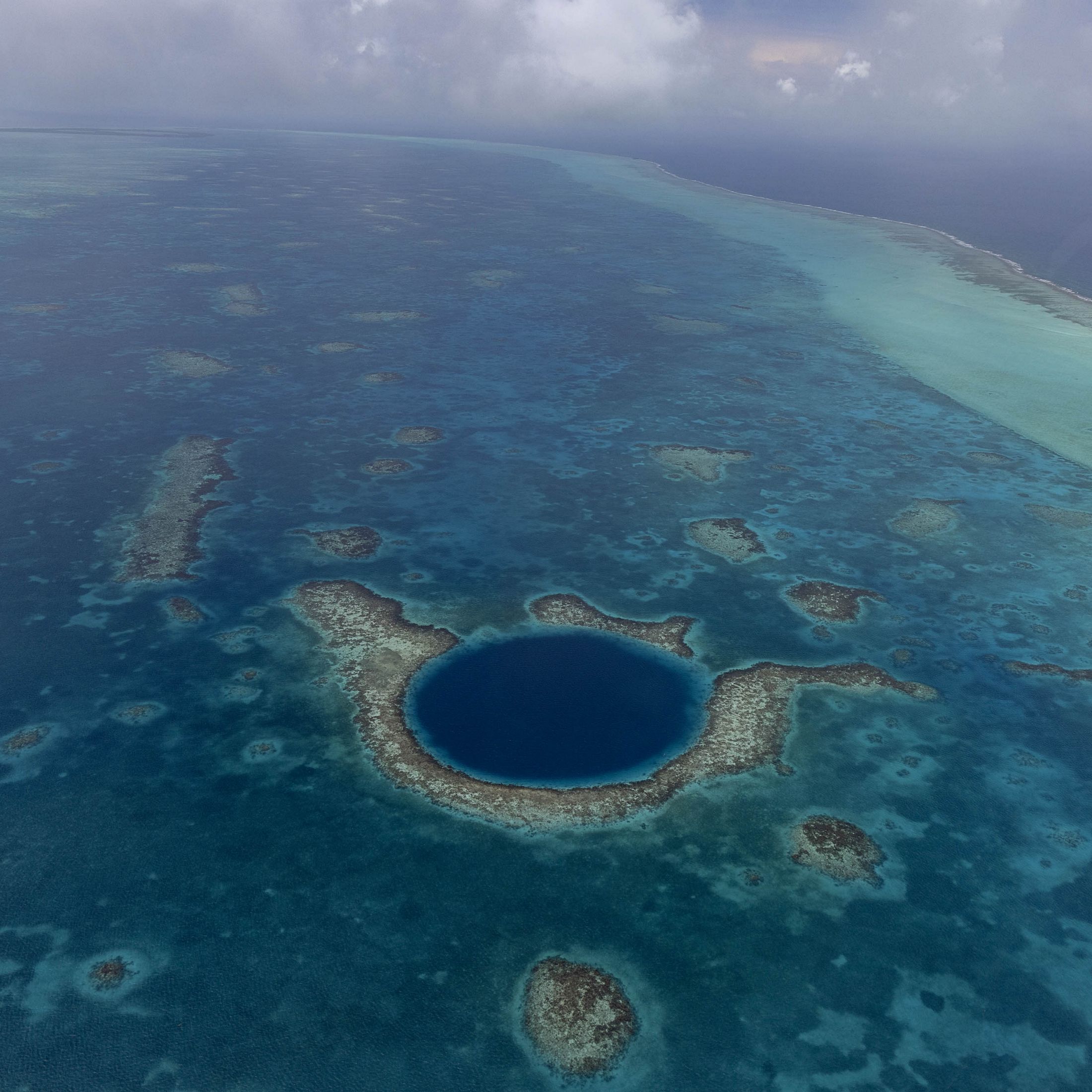 The Great Blue Hole is a circle of darker blue off the coast of Belize.