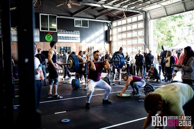 Glenn Ellis Jr. lifts a barbell in a crowded gym space.