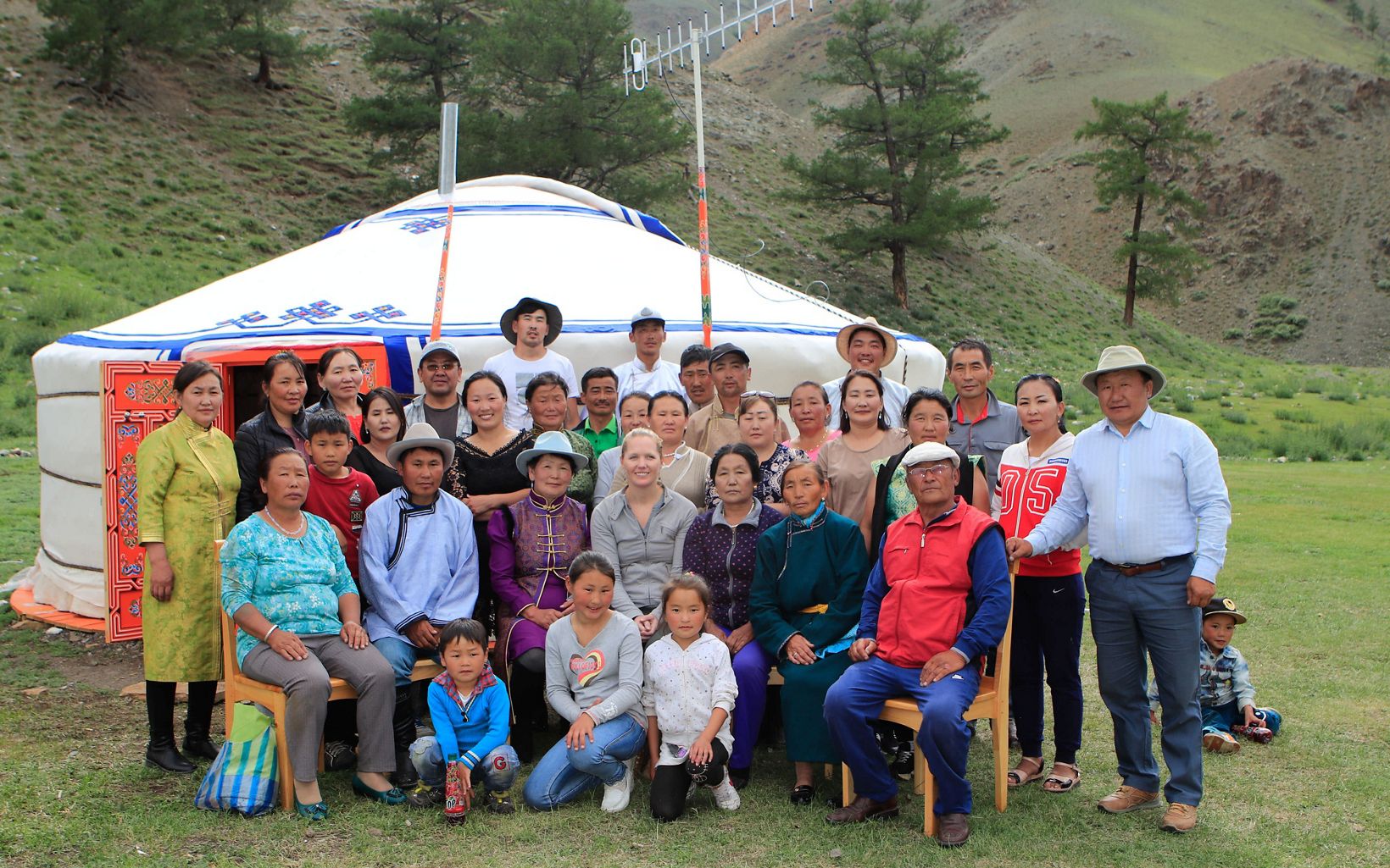 The local community poses in front a Mongolia ger tent at their eco-camp.
