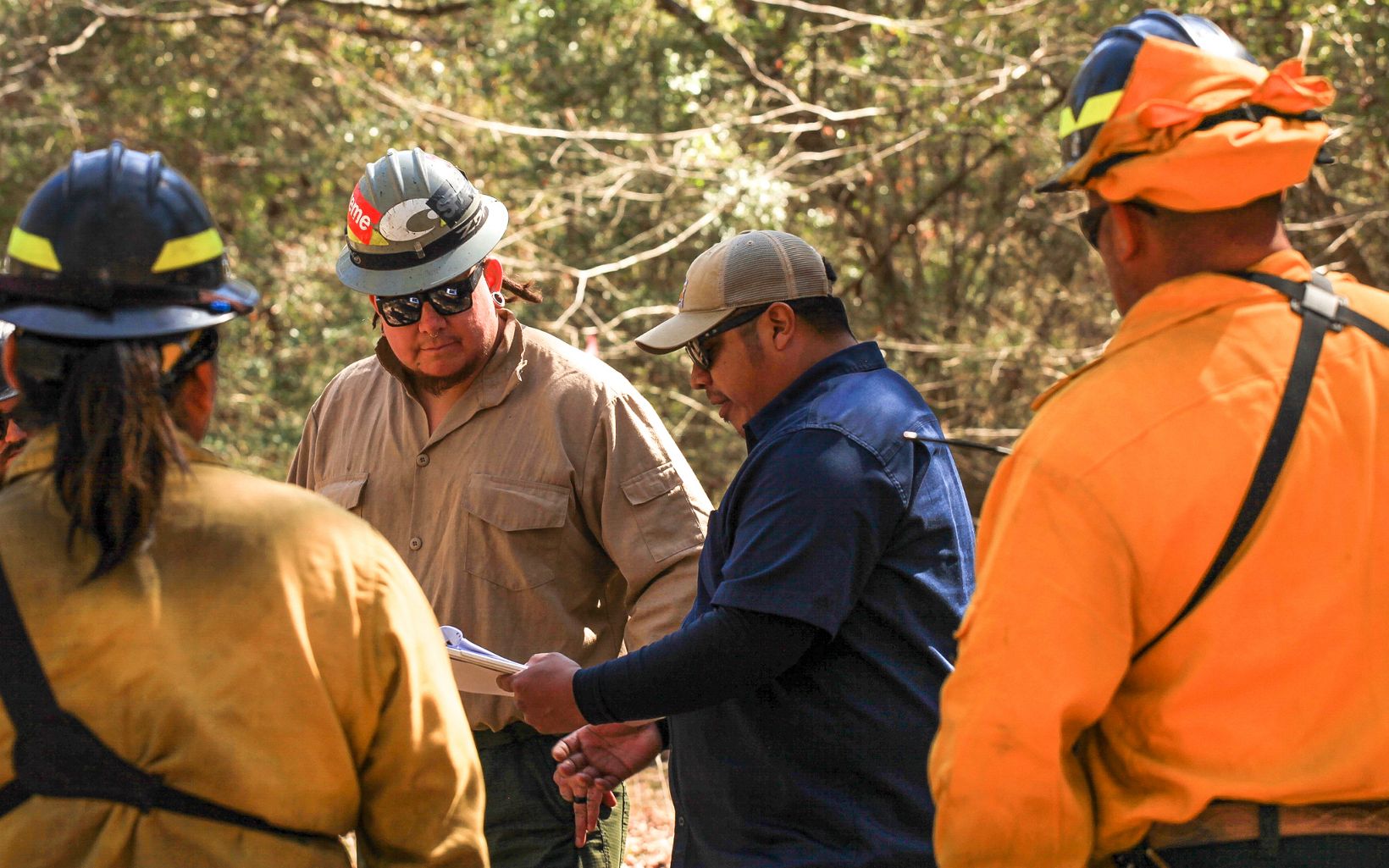 The Beginning Gesse Bullock gathers the tribe's Wildland Fire Management crew for a briefing before a prescribed burn on roughly 50 acres of longleaf pine forest. © Claire Everett/TNC