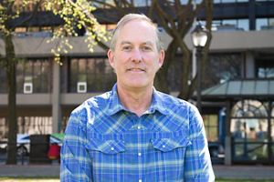 A man wearing a blue shirt poses for the camera.