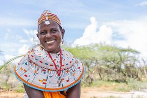 A portrait of a young woman wearing a large beaded necklace and crown.