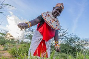 A woman holding a blade of grass.