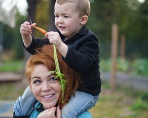 Marina Anderson in Southeast Alaska with a child on her shoulders.
