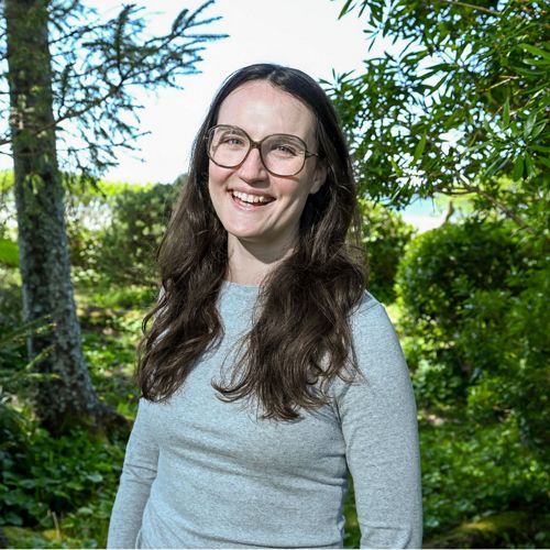 a portrait of alexandra post in front of forest