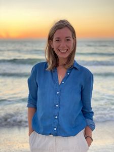 Headshot of Alison Miller on a beach at sunset.