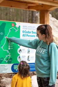 An adult and a child study a map for a nature preserve trail.