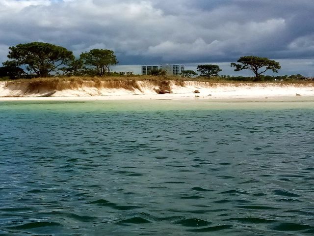 view of a sandy island from the water.