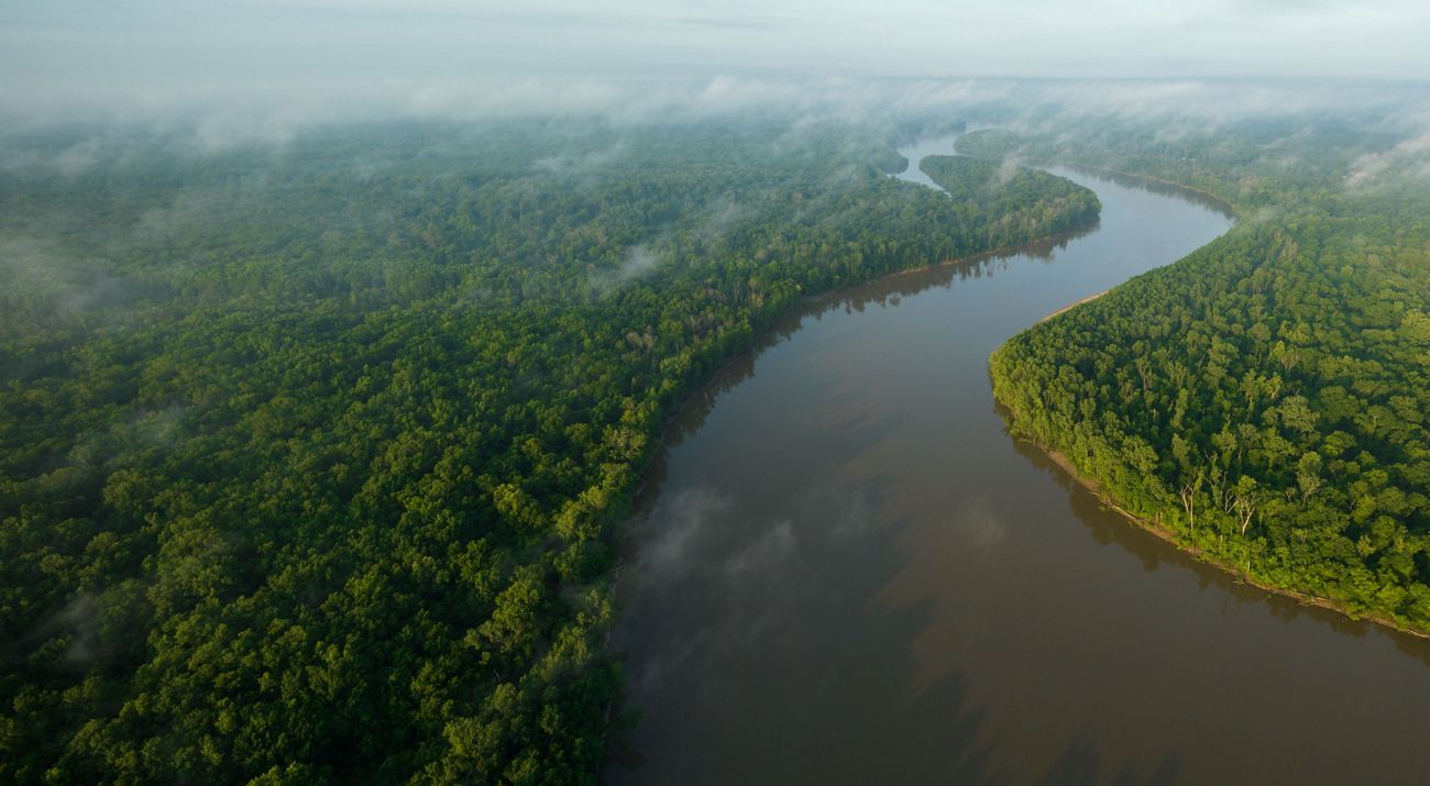 Willowy clouds float over a river's calm waters.