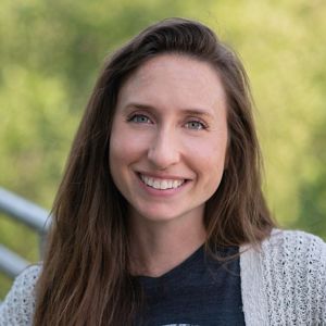 Person smiling in front of nature.