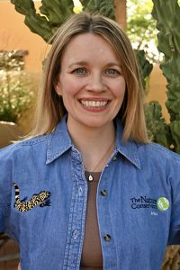 Headshot of a woman wearing a denim shirt and blond hair smiling at the camera.