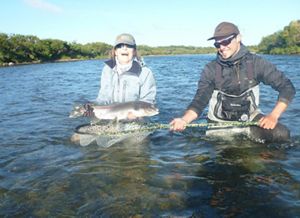 Angela Nomellini standing in water holding a large fish.