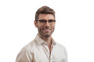 A man with glasses smiles at the camera.