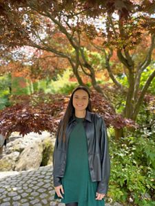 Portrait of Astrid Peraza standing outside with trees behind her.