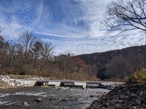 The newly complete bridge crosses a stream.