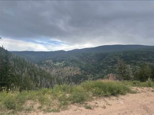 Dark gray clouds hang low and heavy over a mountain ridge.