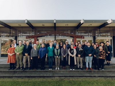 A large group of people stand in front of a building.