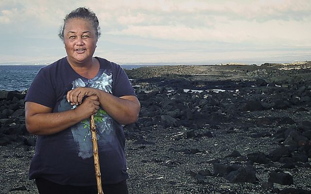 Leina‘ala “Aunty Lei” Lightner stands on a rocky shore in Hawaii.