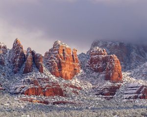 View of a red rock mountain covered in snow.