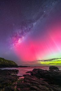 The night sky in shades of bright pink, green and purple.
