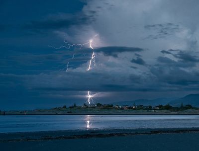 Lightning strikes against a dark sky.
