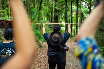 A man holding a ceremonial tool above his head. 