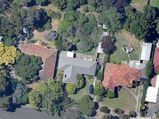 Aerial image of three dwellings surrounded by vegetation