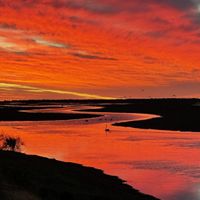 Bright orange sunset over a winding river 