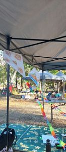 Hand made kites hanging from the tent in the breeze.