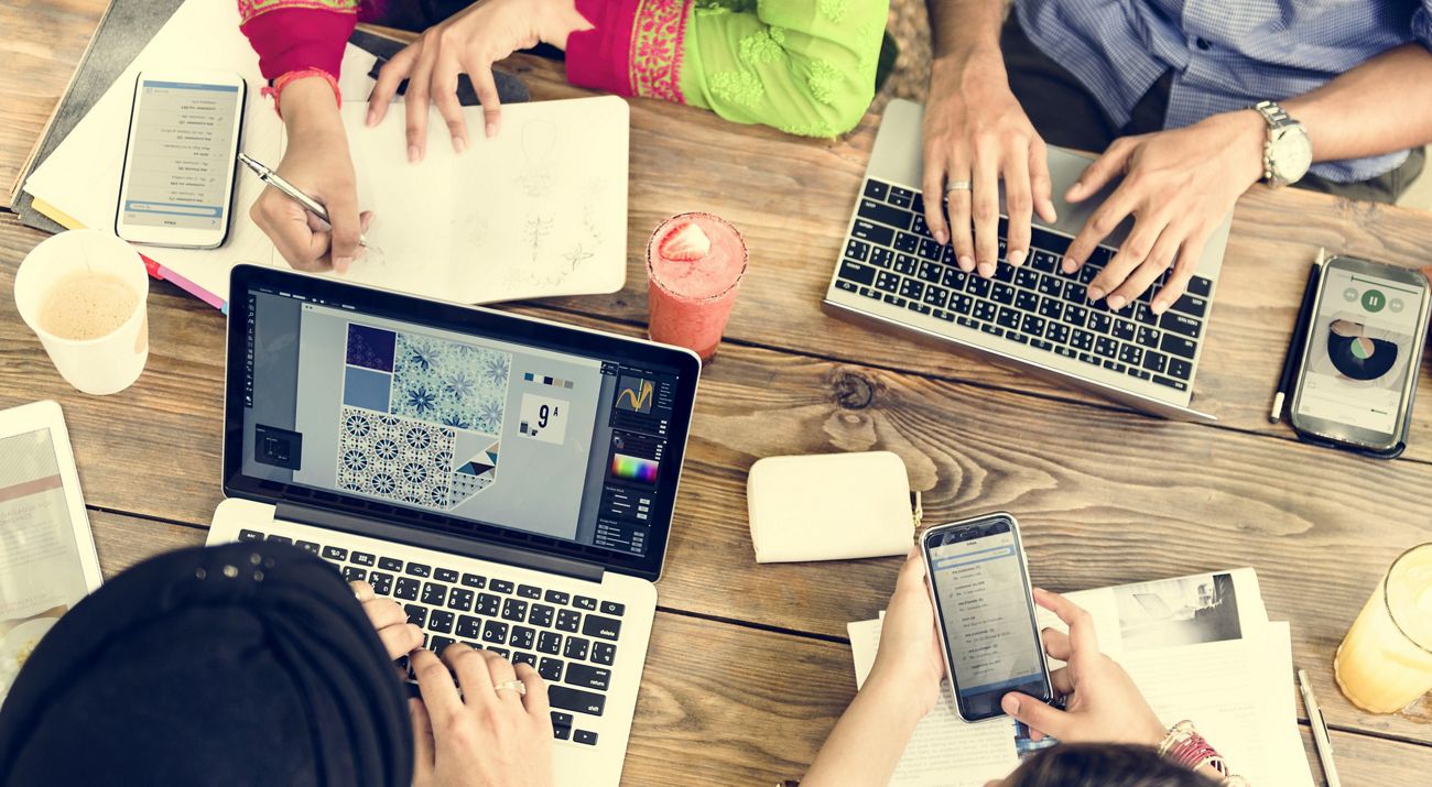 above view of people working at laptops on a table.