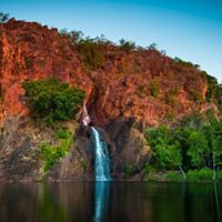 a small waterfall down red cliffs