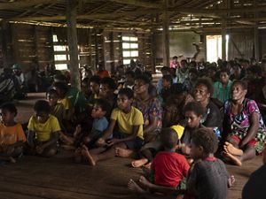 Community meeting including women and children in Papua New Guinea.
