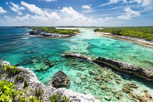 An aerial shot of coral reef with the coral jutting above the water line. 