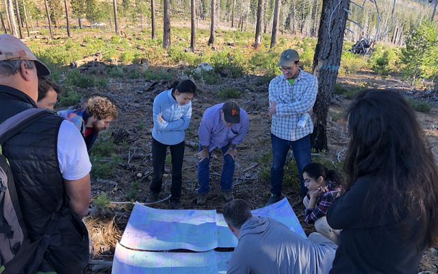 The Bain and TNC teams studying a map on the ground.