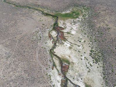An aerial view of a hot spring in the desert.