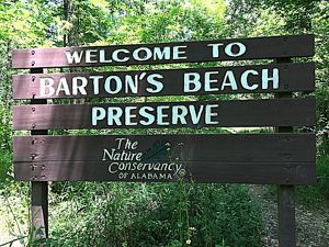 White lettering on a wooden sign announces a nature preserve.