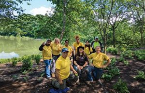 A group of people smiling after planting trees.