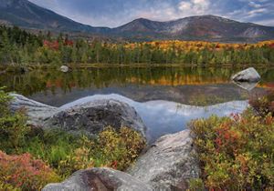 A lake surrounded by colorful trees and mountains.