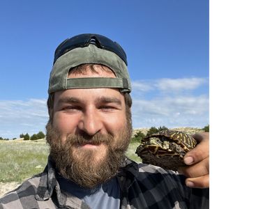 Ben smiling at camera holding a box turtle.
