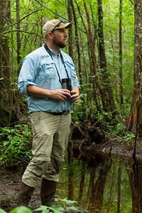 Man with binoculars looking to the right. 