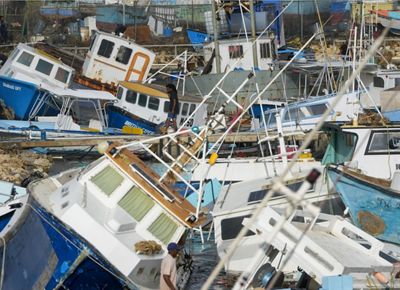 fishing boats laying on top of each other after a hurricane