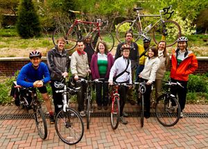 Eleven TNC employees who commute to work by bicycle pose with their bikes.