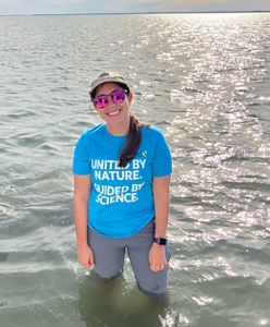 Candid portrait of Mariana Camacho standing in thigh deep water in a coastal Virginia bay.