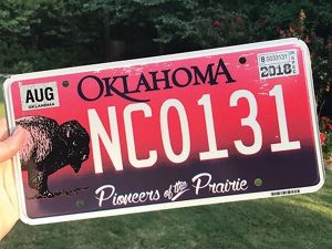 A red Oklahoma license plate featuring an adult bison and the words 'Pioneers of the Prairie' 