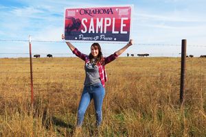 Women holding bison license plate mockup.